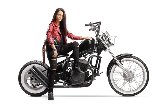 Young woman holding a helmet and sitting on a custom motorcycle