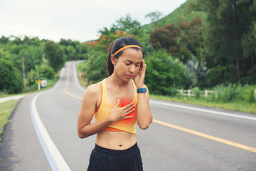 Communicates the symptoms of heart disease,immediately, Asian sport girl with chest pain suffering...
