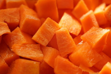 Small square raw carrot slices background. Healthy vegan food