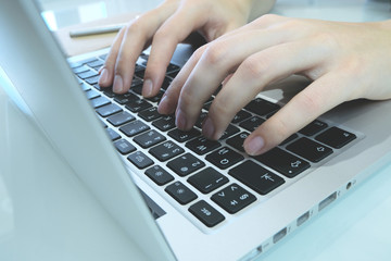 MacBook and women's hands. Work behind the laptop. Keyboard and fingers. Working in the home office.
