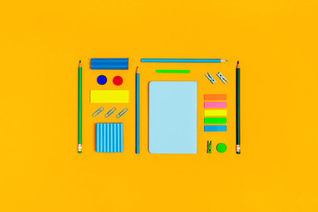 Back to school picture. Color accessories on a yellow background. Central composition.