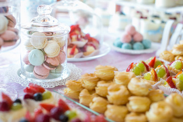 Fototapeta na wymiar Wedding Reception Table setting. Colorful macarons and cakes.