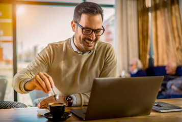 Young handsome man enjoy coffee working on laptop