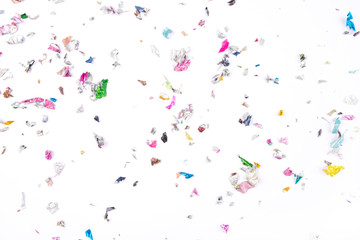 Multicolored confetti on white background. Flat lay, top view.