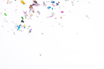 Multicolored confetti on white background. Flat lay, top view.