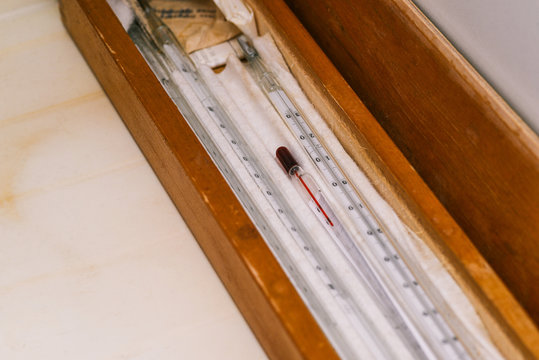 Glass mercury thermometer in a wooden case. Old instrument for measuring the temperature of liquids and use in the laboratory.