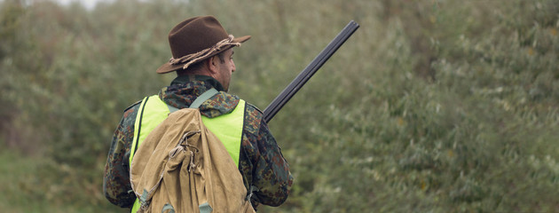 Hunters with a german drathaar and spaniel, pigeon hunting with dogs in reflective vests.