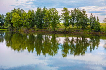 Fototapeta na wymiar classic nature landscape with clear lake, green grass and few trees