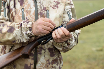 Charges a hunting smooth-bore rifle, hunting a pheasant with dogs. A hunter in camouflage is...