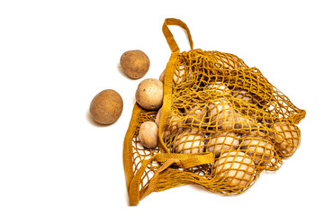 Fototapeta premium Potatoes in a string bag on a white background.