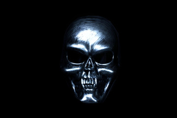 Silver mask skull with sharp teeth on a black background