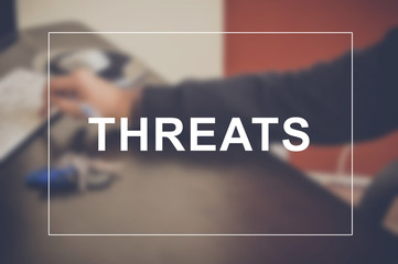 Threats word with business blurring background