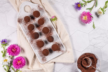 Fine chocolate truffles on white ceramic plate.