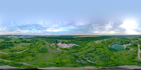 360 degree panorama over granite and sand extraction. Beautiful panorama of green fields and meadows and two large lakes. A revolution from a drone. Height 250 meters above the granite quarry