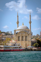 Fototapeta na wymiar Beşiktaş, İstanbul /Turkey - April 19 2019: boat passing in front of Ortakoy Mosque, also known as the Mecidiye Mosque