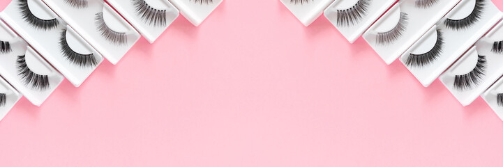 Different fake eyelashes on a trendy pastel pink background. Beauty pattern. Makeup accessories....