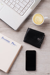 Personal items and cappuccino close up. PC and planner. Wallet and mobile. Minimalism concept.