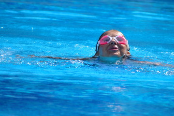 Fototapeta na wymiar child girl swimmer in the pool. Sporting healthy summer vacation with the kids.