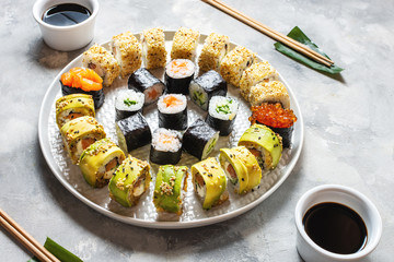 Various kinds of sushi served on concrete background.