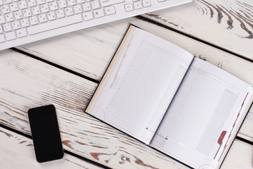 Organizer, keyboard and cellphone on wooden background. Office days.