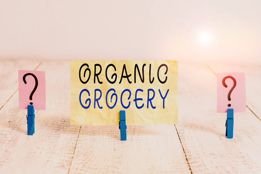 Writing note showing Organic Grocery. Business concept for market with foods grown without the use of fertilizers Crumbling sheet with paper clips placed on the wooden table