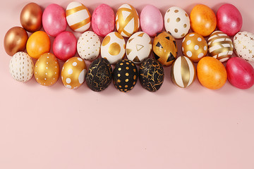 Decorated golden easter eggs on a pink background. Minimal holiday concept. Happy easter background. Creative painting of eggs at home, the idea of simple drawings for coloring, a place for text, 
