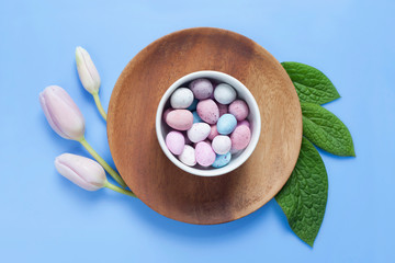 Blue  pastel Easter with delicate tulips, sweet meringues and sugar-coated chocolate eggs.