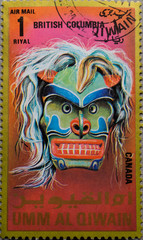Canadian indigenous dance mask with facial paints and long hair showing teeth