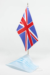 Medical mask on the background of the flag of Great Britain, isolated, coronavirus concept (COVID-19), closeup