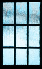 Colored light is visible through the frozen glass. Ice patterns on a frozen window.