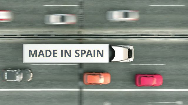 Aerial overhead view of trailer trucks with MADE IN SPAIN text driving along the highway. Spanish business related loopable 3D animation