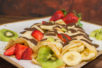 Healthy crepes with fruits, banana, kiwi and strawberry. Healthy french breakfast