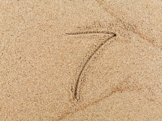 The number 7 on wet beach sand. 
