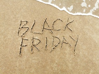 Black Friday poster. Embossing on wet sand. Summer beach background. 