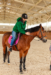 Obraz premium man jockey sitting on horse, horseback training on manege, lesson for jockey in equestrian school or club, pet animal