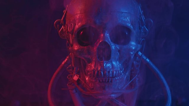 Robotic skull in red and blue light with smoke