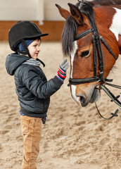 young jockey boy riding horse, horseback training on manege, lesson for young jockey in equestrian school or club, pet animal