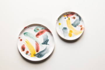 Hand-painted ceramic plates. Collection of colorful ceramic on white background