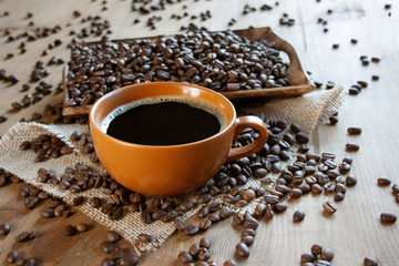  Black coffee in a brown cup on the background of coffee beans