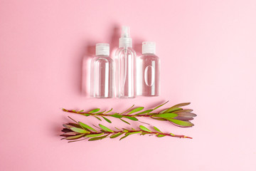 Obraz na płótnie Canvas Organic cosmetics, Green cosmetics, body care products.Composition of three transparent cosmetic bottles and two green twigs with leaves on a pink background, copy space, top view