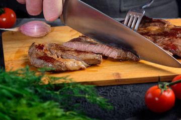 Freshly prepared beef steak is cut into slices. The meat is medium rare.
