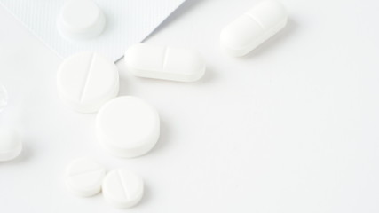 White medical pills coronavirus, white background. Closeup photo of medical preparations with copy spaes.Macro photo.