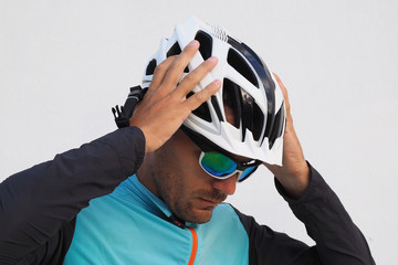 Bicyclist puts on a white helmet..White background.