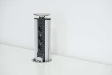 The electric socket is built in the kitchen countertop.