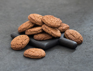Vegan oatmeal cookies scattered on a dark gray background
