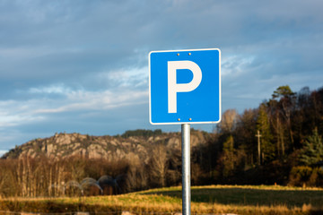 Parking allowed sign. Trees and mountains in the background.