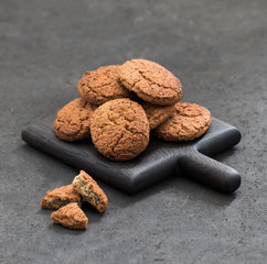 Vegan oatmeal cookies scattered on a dark gray background