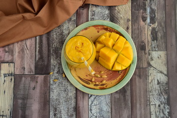 Mango Lassi, Indian popular summer drink served in glass garnish with saffron