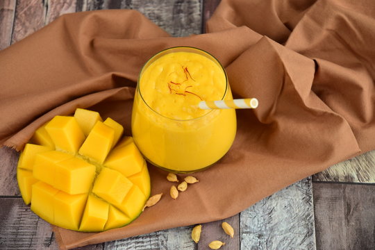 Mango Lassi, Indian popular summer drink served in glass garnish with saffron