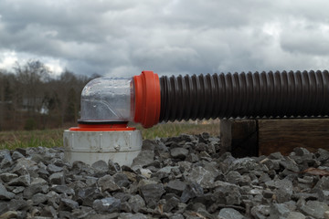 RV sewer hose connected to dump station with 90 degree clear fitting